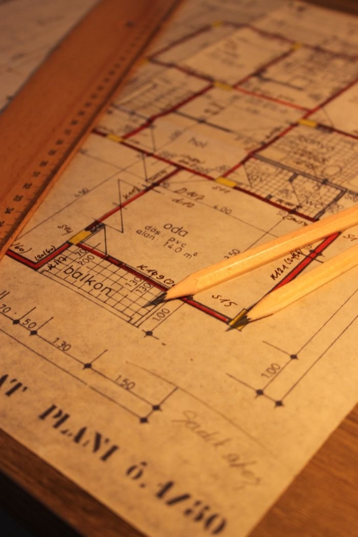 Mengenal PBG Close-up of architectural floor plan with pencil and ruler, ideal for design concepts.